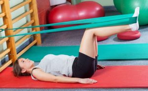 Egzersiz bandı ile antrenman yapan kadın.