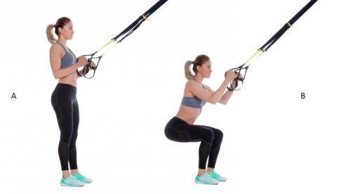 TRX ile squat egzersizi yapan bir kadın