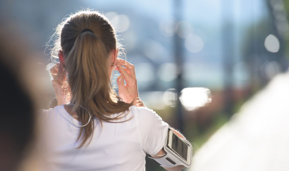 Müzik dinleyerek koşan kadın.