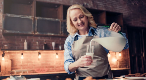 bardağa sürahiden süt dolduran kadın