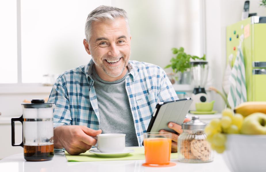 kahvaltı yapan orta yaşlı mutlu adam