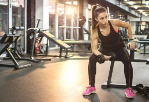 Dambıl ile ağırlık çalışan kadın