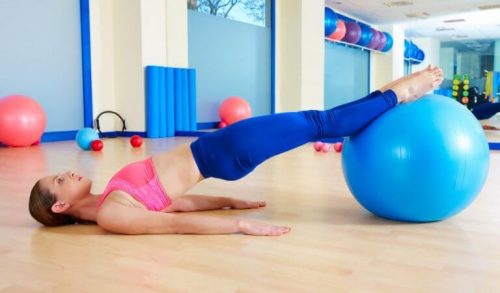 kadın pilates topu ile spor yapıyor