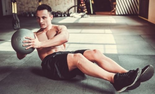 Sağlık topu ile karın egzersizi yapan bir adam.