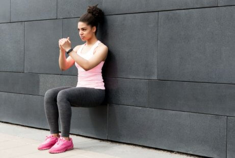 duvara yaslanmış squat yapan kadın