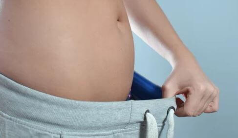 Beli bol gelen eşofmanını gösteren kadın