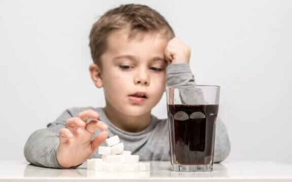 önünde kola ve şeker bulunan küçük çocuk