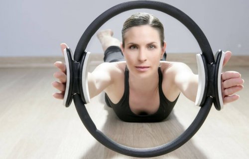 pilates çemberi ile egzersiz yapan kadın