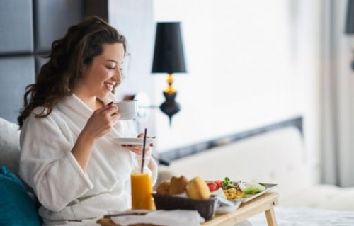 yatakta kahvaltı eden kadın