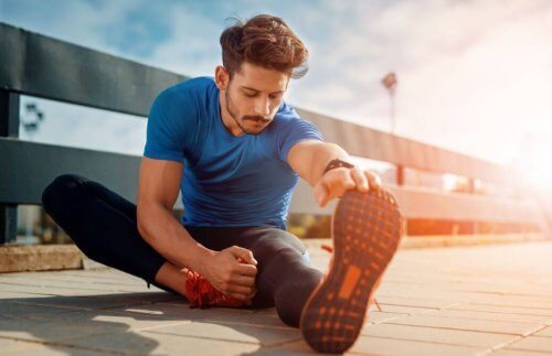 spordan sonra yerde bacak germe hareketi yapan adam