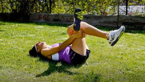 çimde psoas ilyak esnetme hareketi yapan sporcu