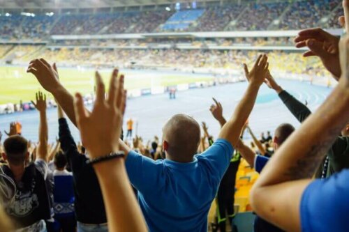 maç izlerken elleri havada ayakta duran seyirciler