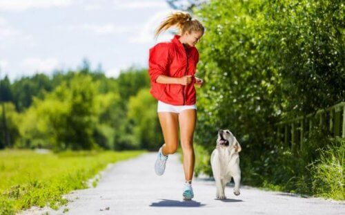 parkta golden cins köpeği ile koşan kırmızılı kadın