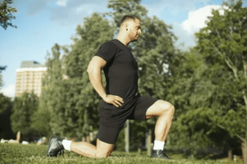 Dinamik esneme egzersizleri yapan bir adam.