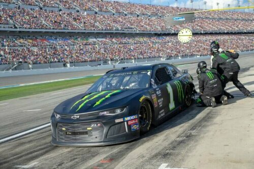 Bir araba ile ilgilenen bir pit ekibi.