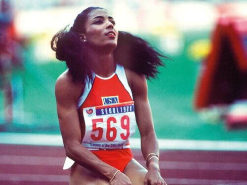 Bir yarıştan sonra yere diz çökmüş Florence Griffith.