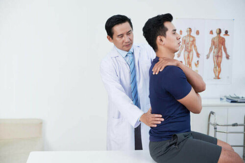 Bir sporcunun sırtını kontrol eden bir doktor.