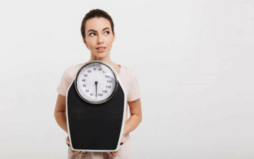 Elinde tartı tutan bir kadın.